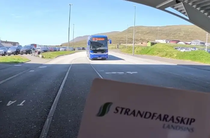 A blue public bus on a road in the Faroe Islands