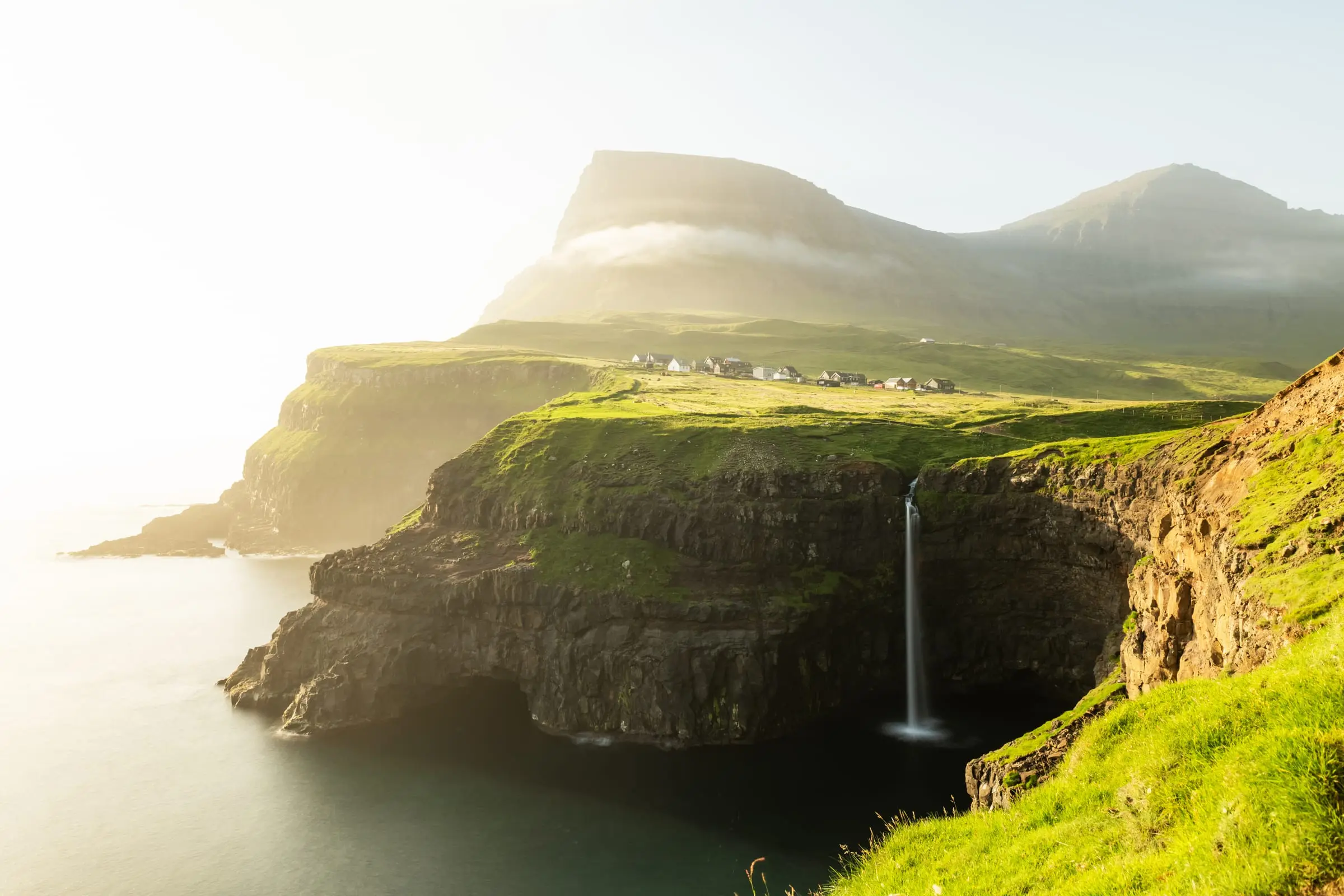 The Múlafossur waterfall dropping into the sea beside the village of Gásadalur