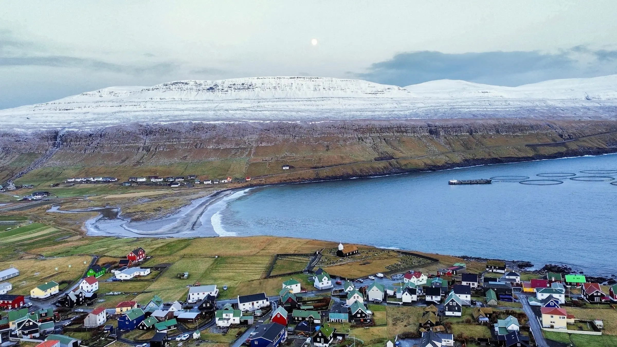 Playa de arena y casas del pueblo de Sandur, en Sandoy